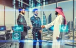 A dynamic business partnership scene with representatives from Panamax Technology and Hilal Technology shaking hands. The background features a modern