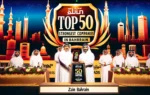 A prestigious award ceremony scene with Zain Bahrain representatives receiving an award. The backdrop features a large banner with the text 'Top 50 St