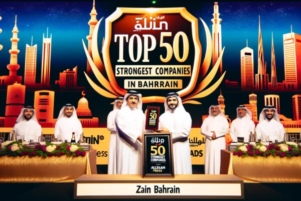 A prestigious award ceremony scene with Zain Bahrain representatives receiving an award. The backdrop features a large banner with the text 'Top 50 St